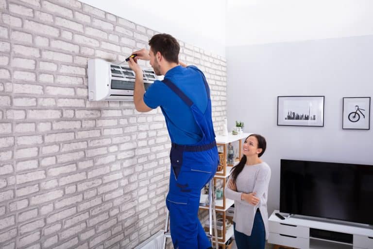 Smiling,Woman,Looking,At,Male,Technician,Repairing,Air,Conditioner,With
